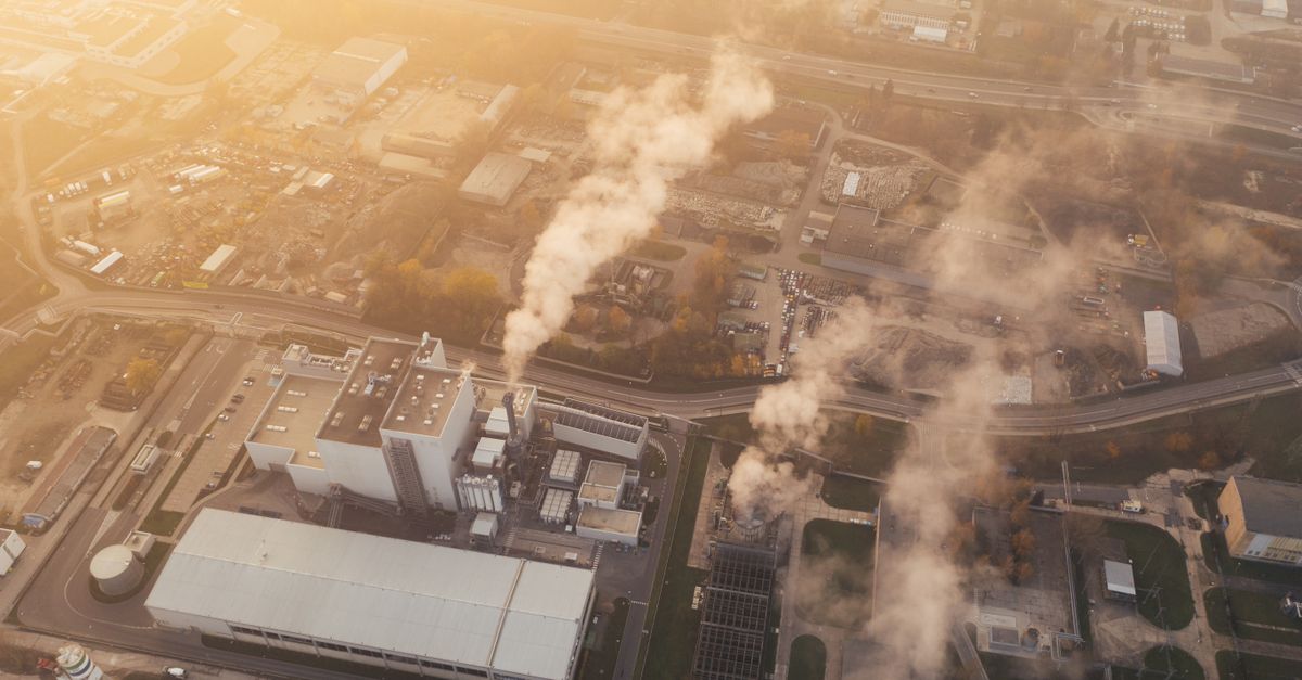 An aerial shot capturing a factory complex with visible smoke in Poznan, Poland.