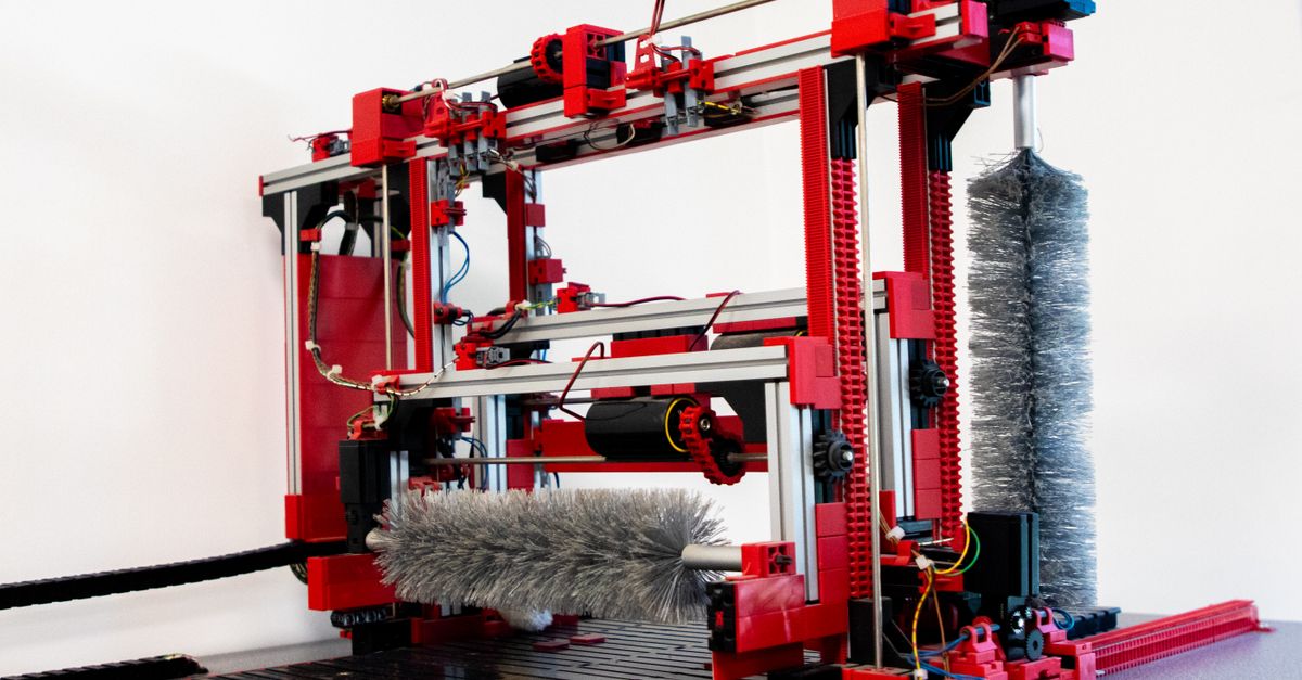 Close-up of a red industrial machine indoors, focusing on intricate machinery and components.