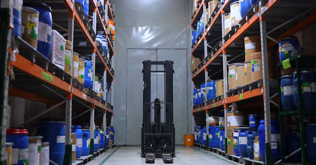 A well-organized pharmaceutical warehouse with shelves and a forklift in Islamabad, Pakistan.
