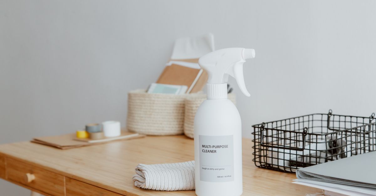Minimalist desk with a focus on a multipurpose cleaner, office supplies, and storage solutions.