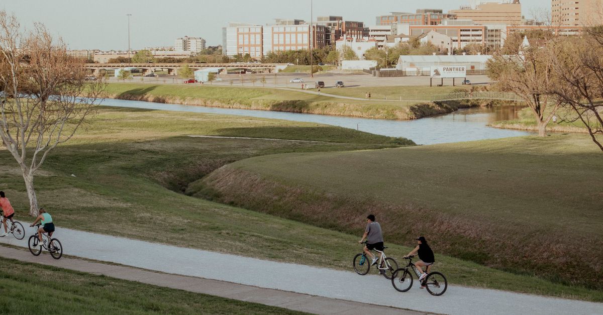 Bicyclists ride along a scenic path in Fort Worth, capturing the essence of outdoor activity.