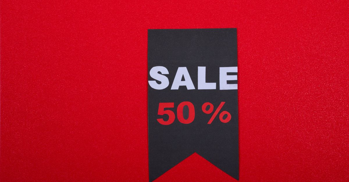 Black sale tag on red background highlighting 50% discount.