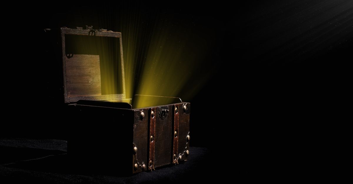 Open wooden chest emitting a mysterious glowing light in a dark room.