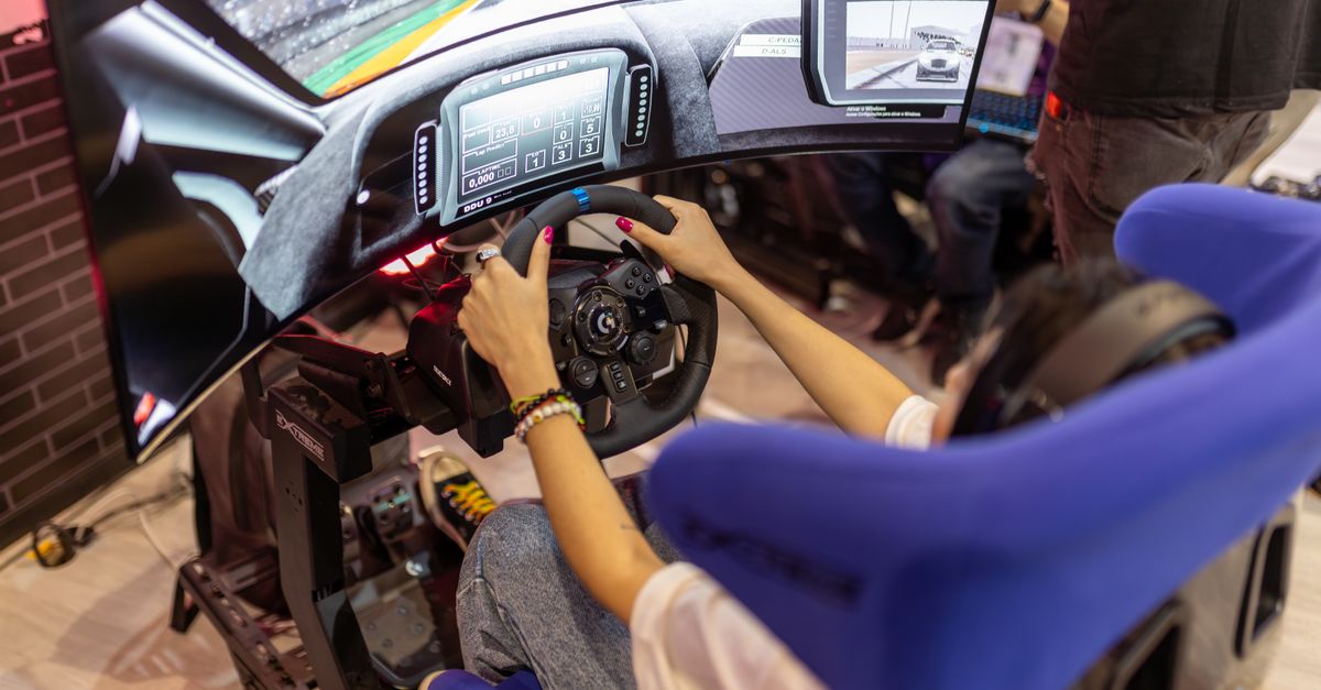 Person using a realistic VR racing simulator at a gaming event, focused on the immersive experience.