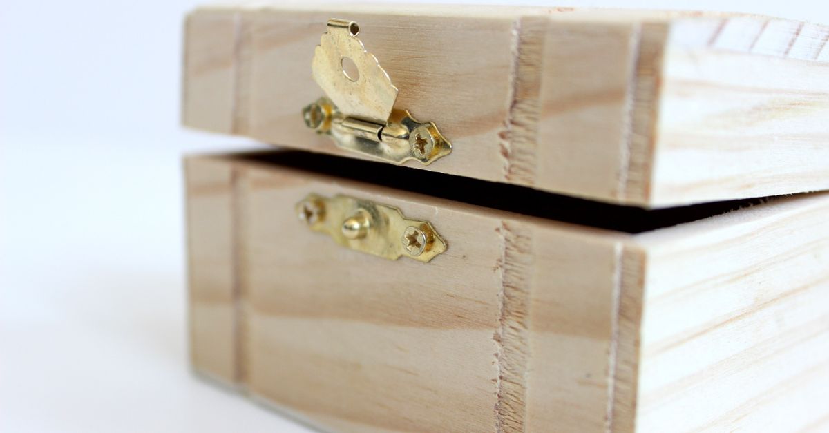 A close-up of an open wooden box with a brass latch, ideal for storage or decoration.