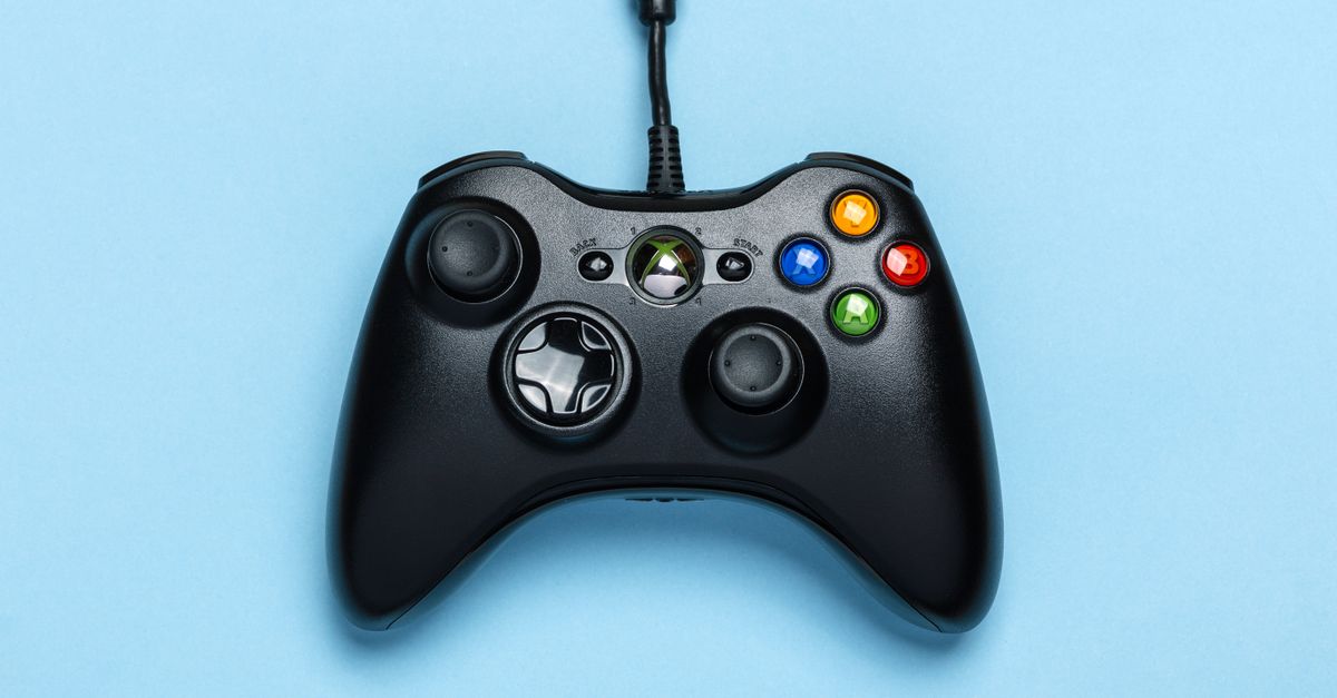 Black video game controller isolated on a blue background for gaming enthusiasts.