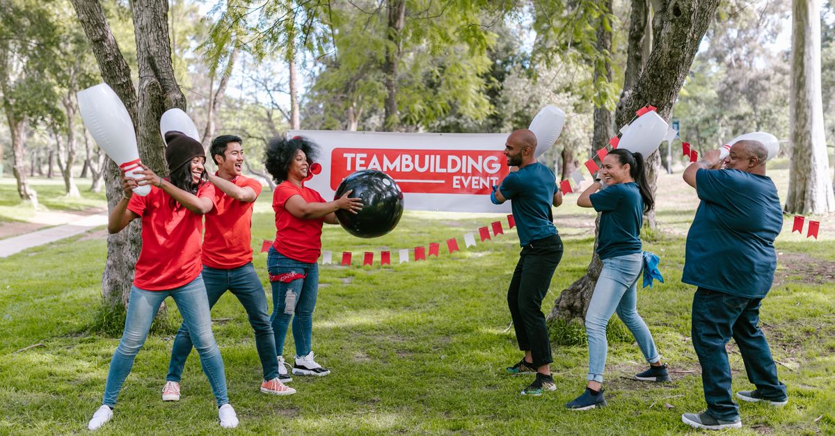 Dynamic outdoor team building activity with diverse group playing in the park.