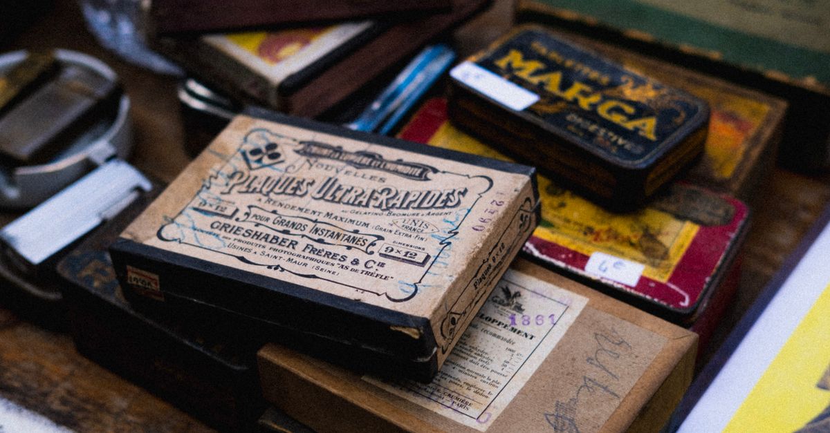 Close-up of retro boxes and tins displayed at flea market, conveying nostalgia.