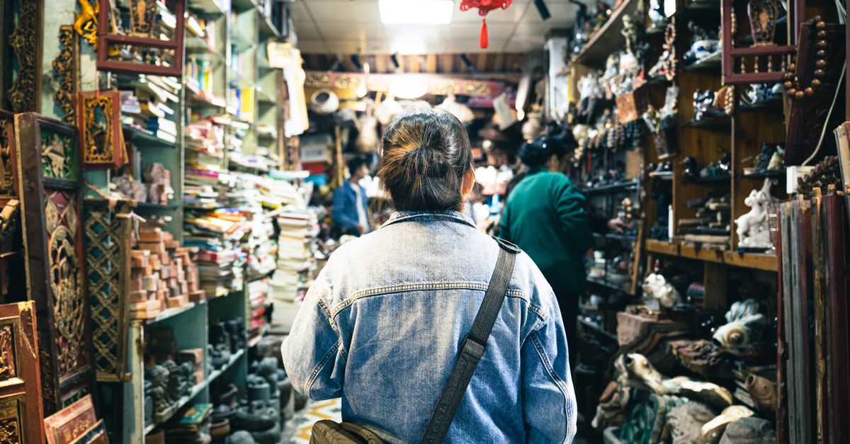 A person browsing through a bustling antique store filled with vintage treasures and cultural artifacts.