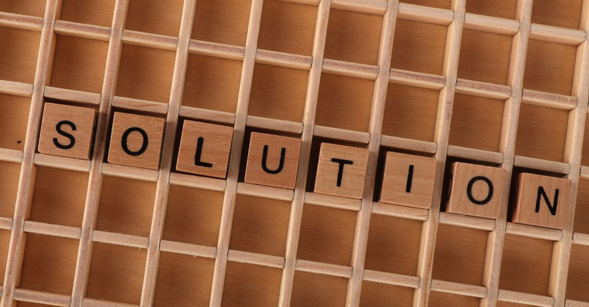 Wooden blocks spelling 'solution' in a grid, symbolizing problem-solving.