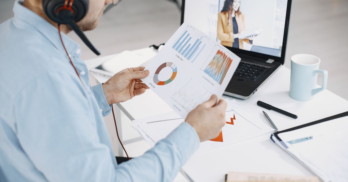 Man reviewing business charts during a remote video call, showcasing data analysis.