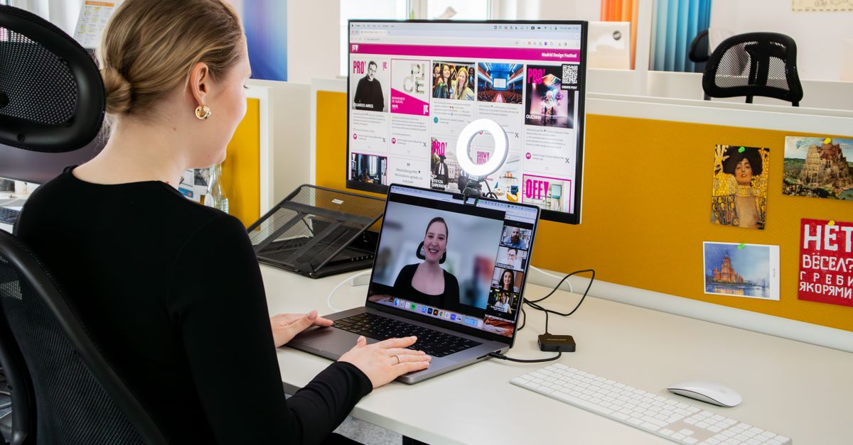 Woman engaged in a video call at her office desk, using technology for remote work and communication.