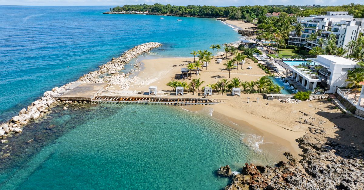 Stunning aerial photo of a beach resort in Sosua, Dominican Republic featuring clear waters, sandy beaches, and lush greenery.