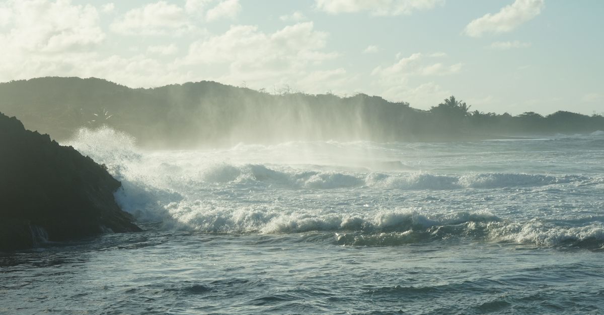Captivating ocean waves crashing against rocks with mist rising at Manati, Puerto Rico.