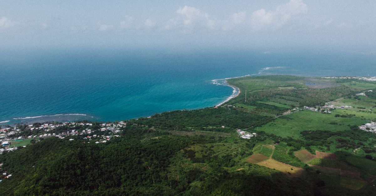 Stunning aerial view of Patillas, Puerto Rico coast with lush fields and clear sea, ideal for travel and nature lovers.