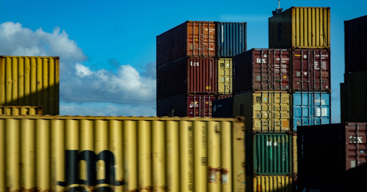 A vibrant display of stacked cargo containers against a clear blue sky.