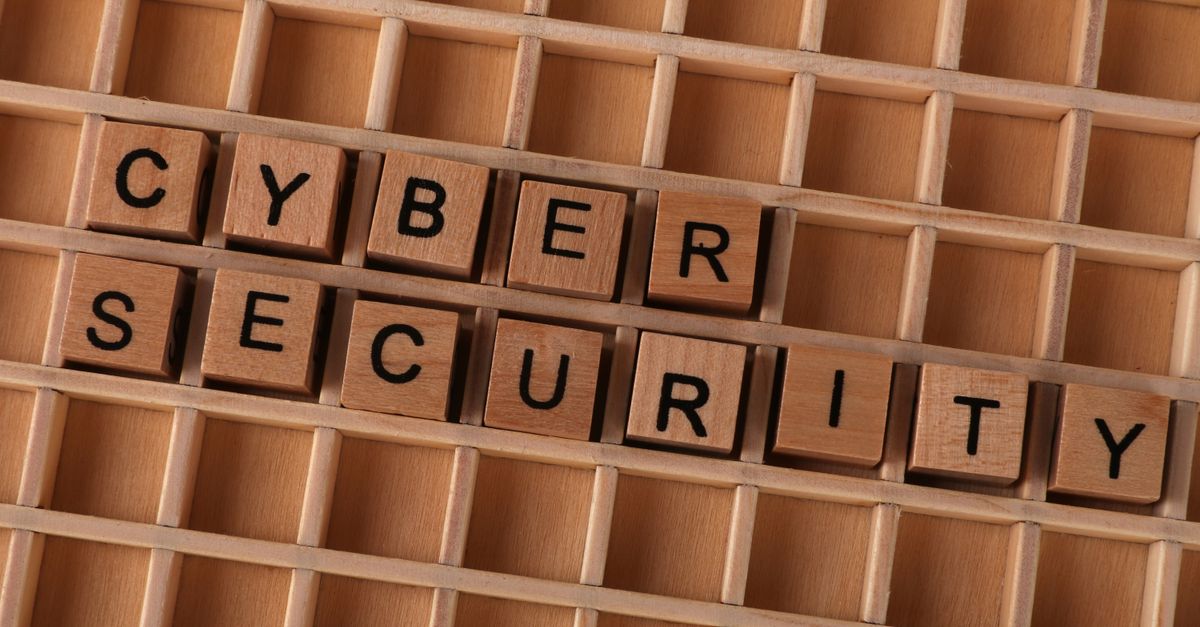 Wooden letter blocks spelling 'CYBER SECURITY' on a wooden grid background for data protection themes.