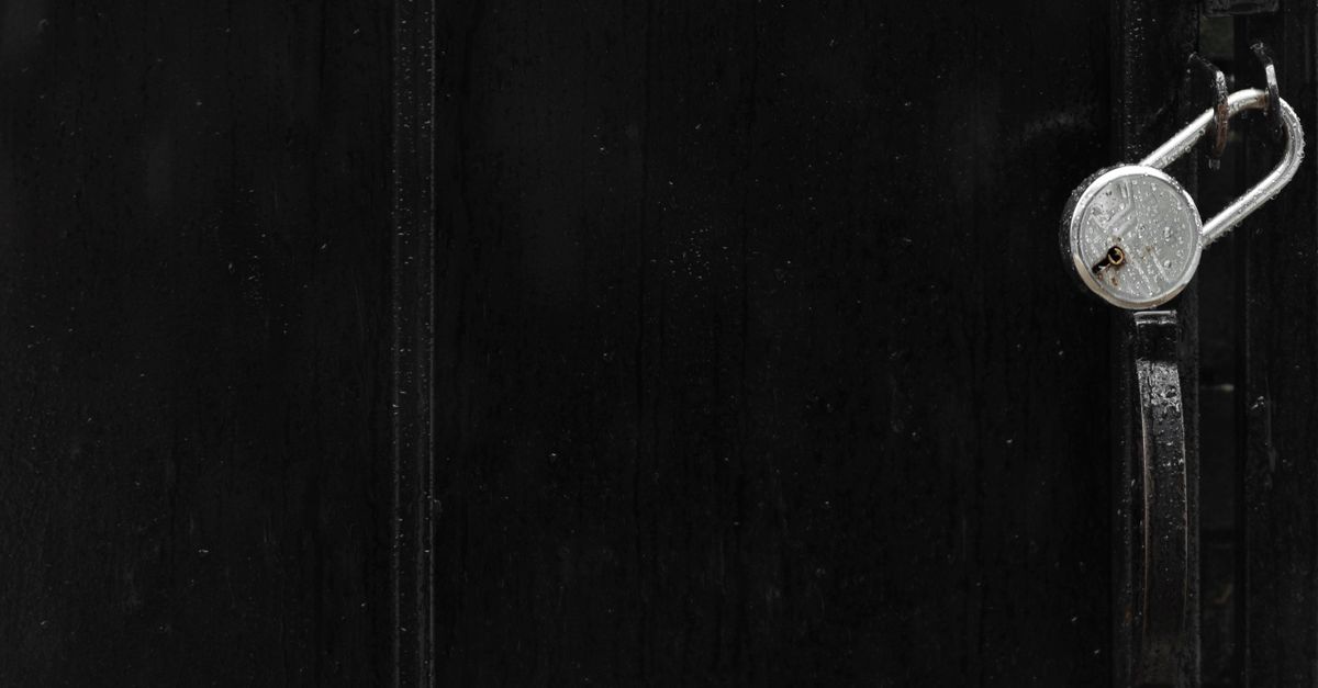 A minimalistic black gate featuring a silver padlock, emphasizing security and secrecy.