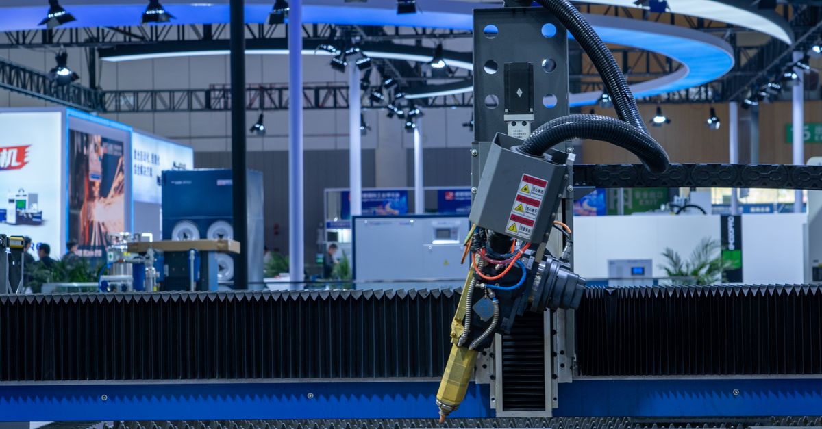 A CNC laser machine operating in a high-tech industrial exhibition setup with vibrant lighting.