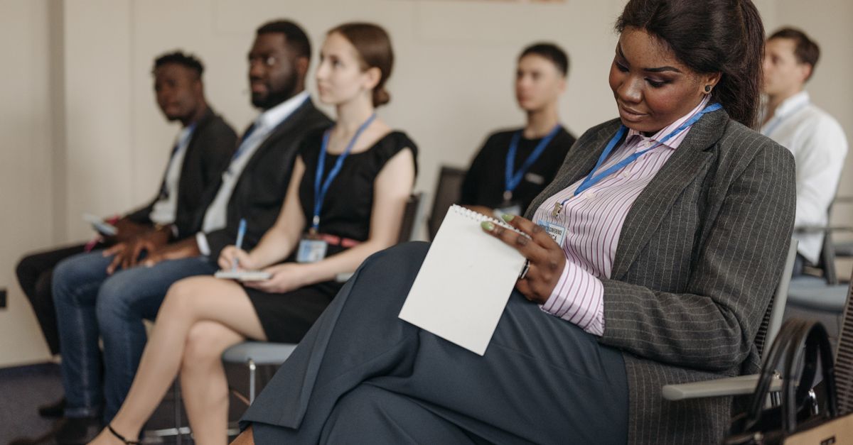Business professionals engaged in a seminar, taking notes and listening attentively.