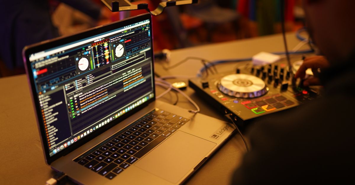 Close-up shot of a DJ setup featuring a laptop and audio mixer, ideal for music events.