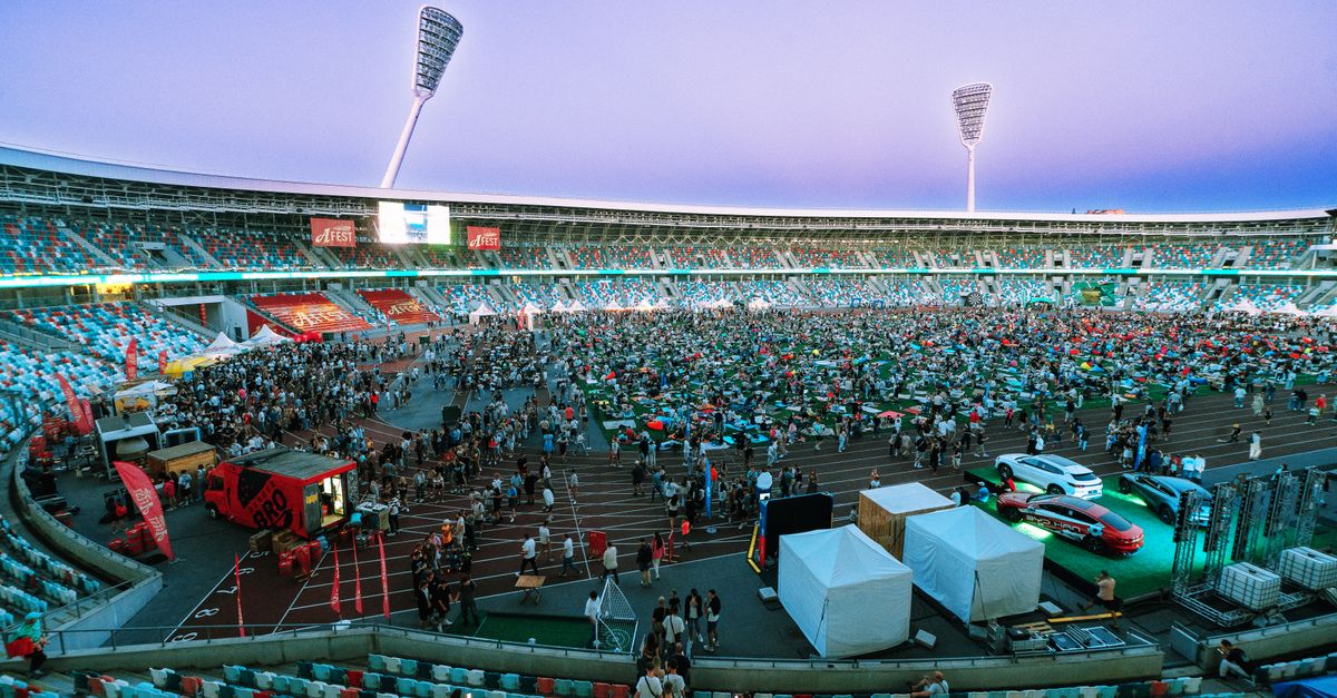 Aerial view of a large crowd gathering in a stadium during twilight. Perfect for event and sports themes.