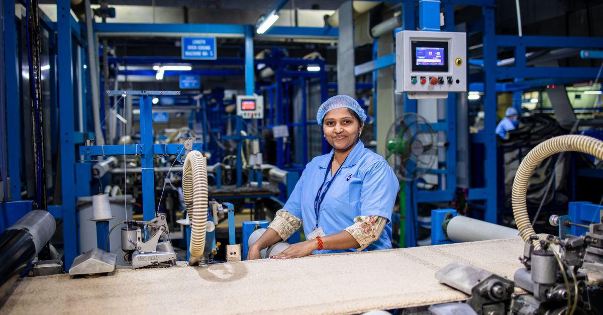 Smiling female worker in a modern textile factory, showcasing the industrial workspace.