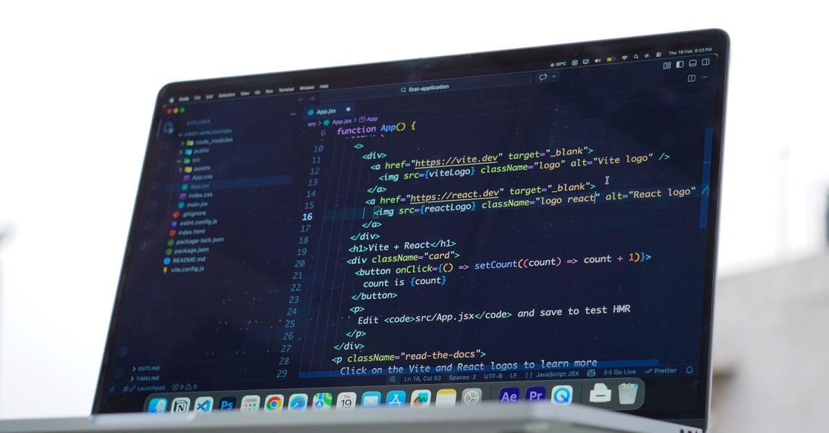 A developer codes on a laptop in an outdoor setting, showcasing modern web development in Surat, India.