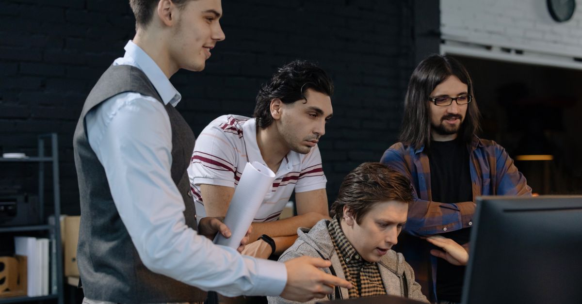 Group of young professionals collaborating on a project in a modern office environment.