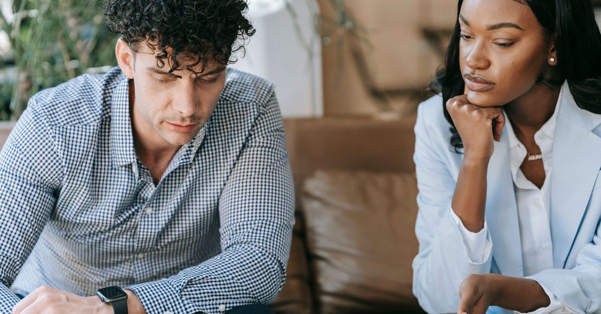 Two business professionals focused on work, collaborating with a laptop.