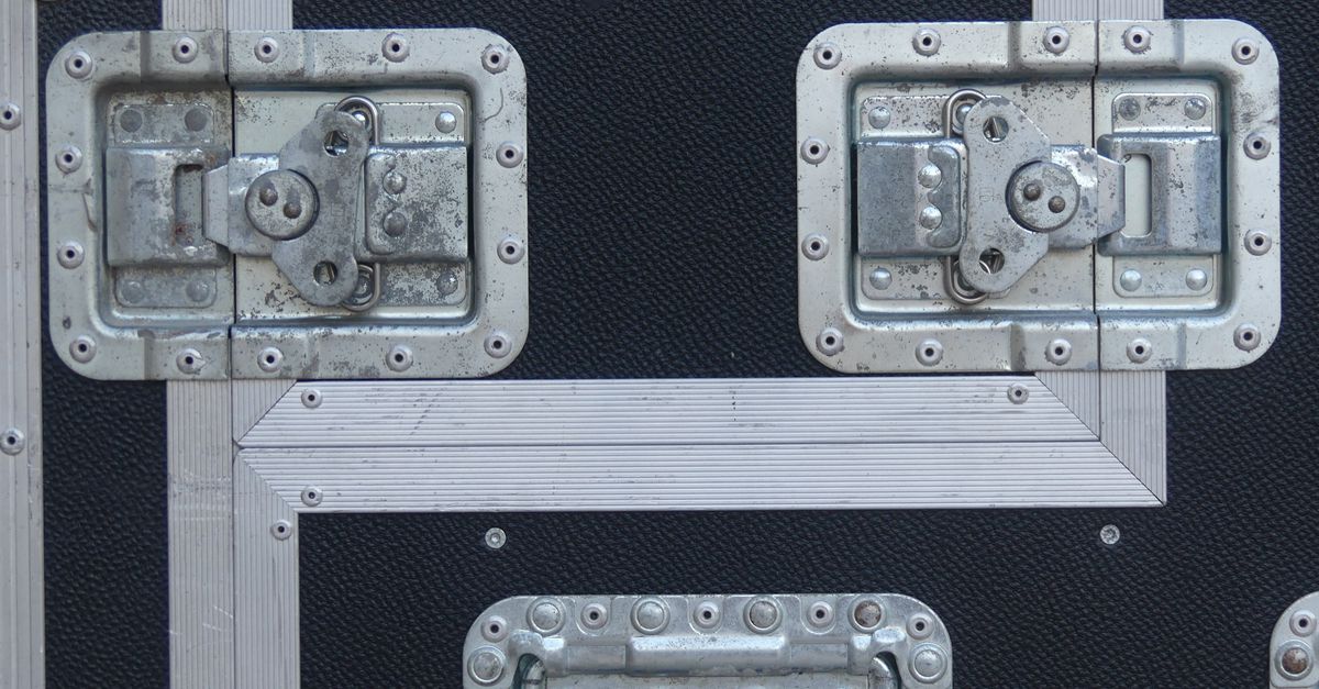 Close-up view of metal latches on a rugged black industrial flight case.