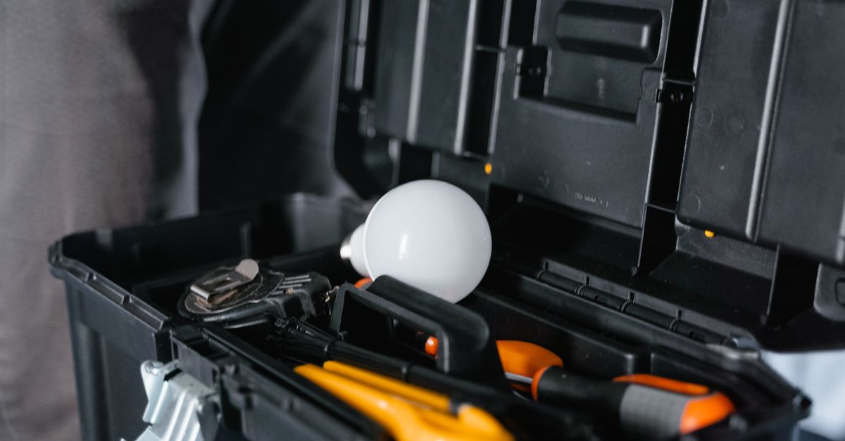 Open toolbox containing various tools and a light bulb.