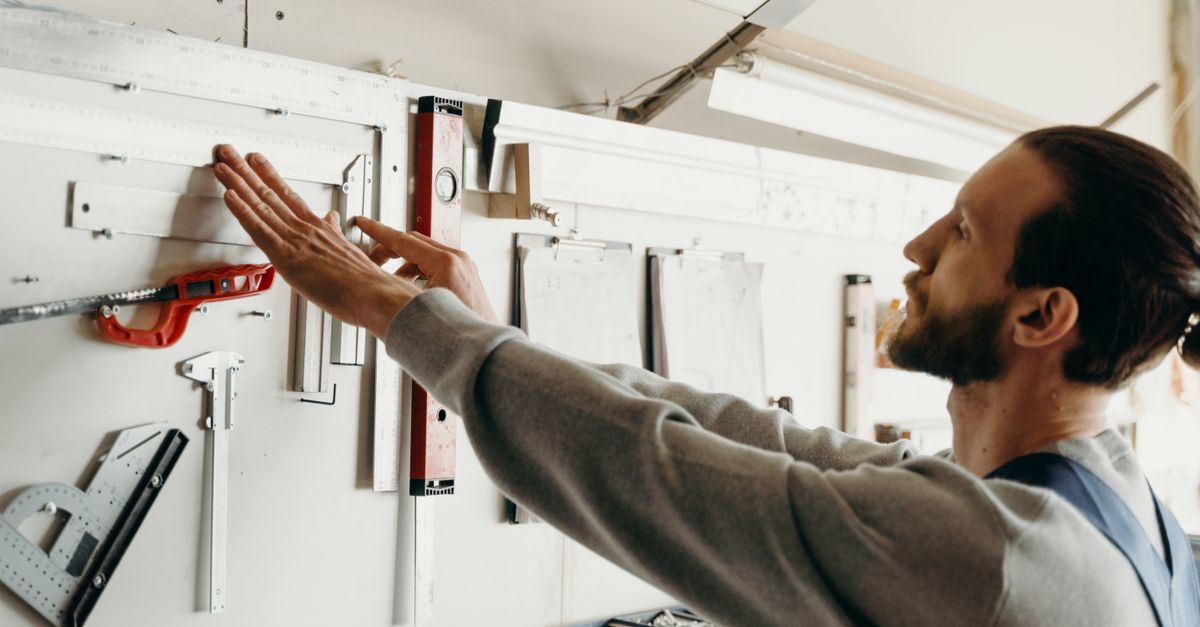 Focused woodworker arranging tools on a workbench, highlighting precision and craftsmanship.