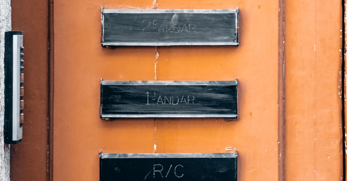 Close-up of a building entrance showing floor signs on an orange wall.
