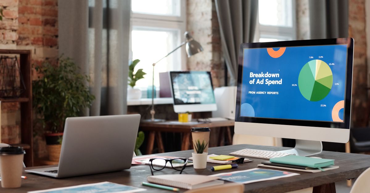 A modern office workspace featuring computers, charts, and office supplies for a productive environment.
