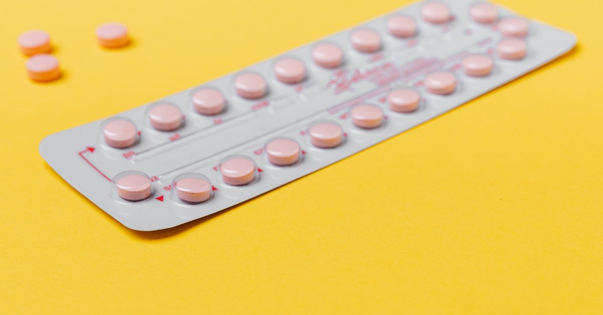 A blister pack of pink pills placed on a vibrant yellow background, symbolizing medicine and healthcare.