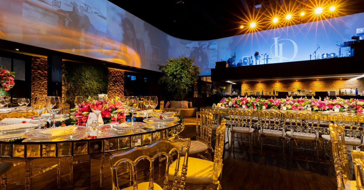 Luxurious indoor wedding venue with elegant table settings and warm lighting.