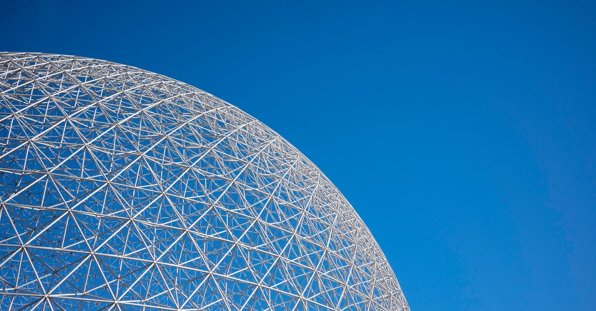 A striking geodesic dome structure set against a clear blue sky, showcasing modern architecture.