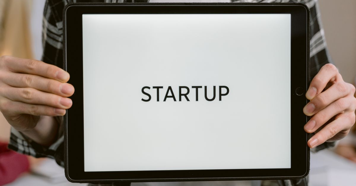 Person holding a digital tablet displaying the word 'STARTUP', representing new business concepts.