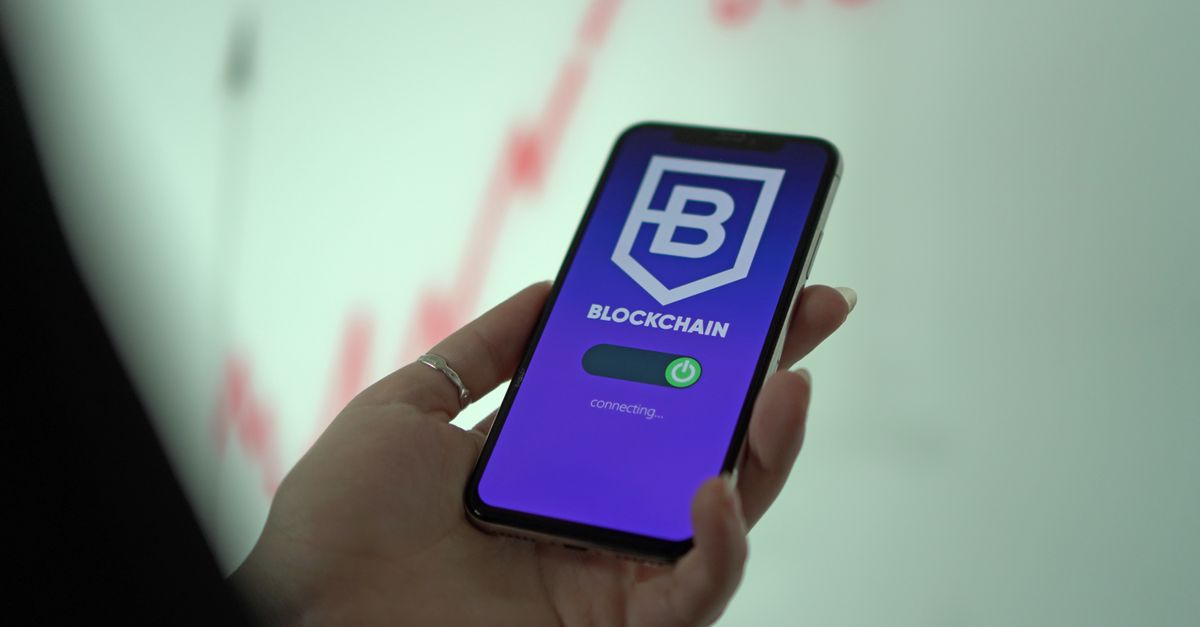 Hand holding smartphone displaying blockchain cryptocurrency wallet.