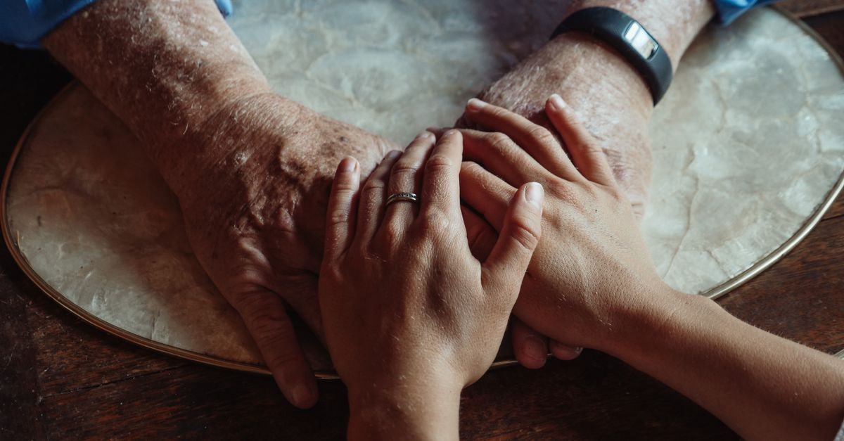 Close-up of elderly and young hands joined, symbolizing compassion and support.