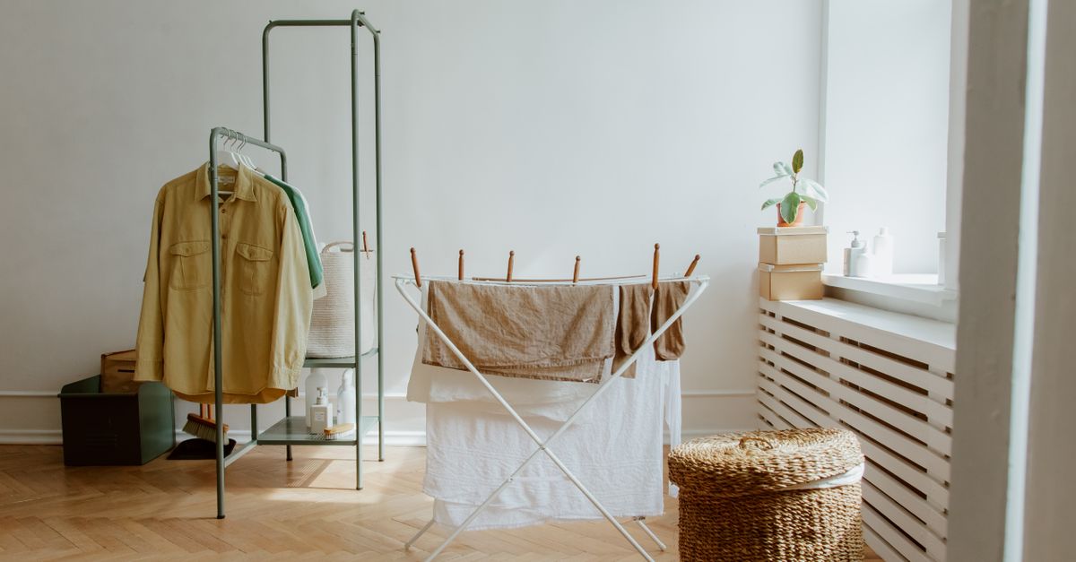 A laundry room with natural light and organized clothes drying setup.