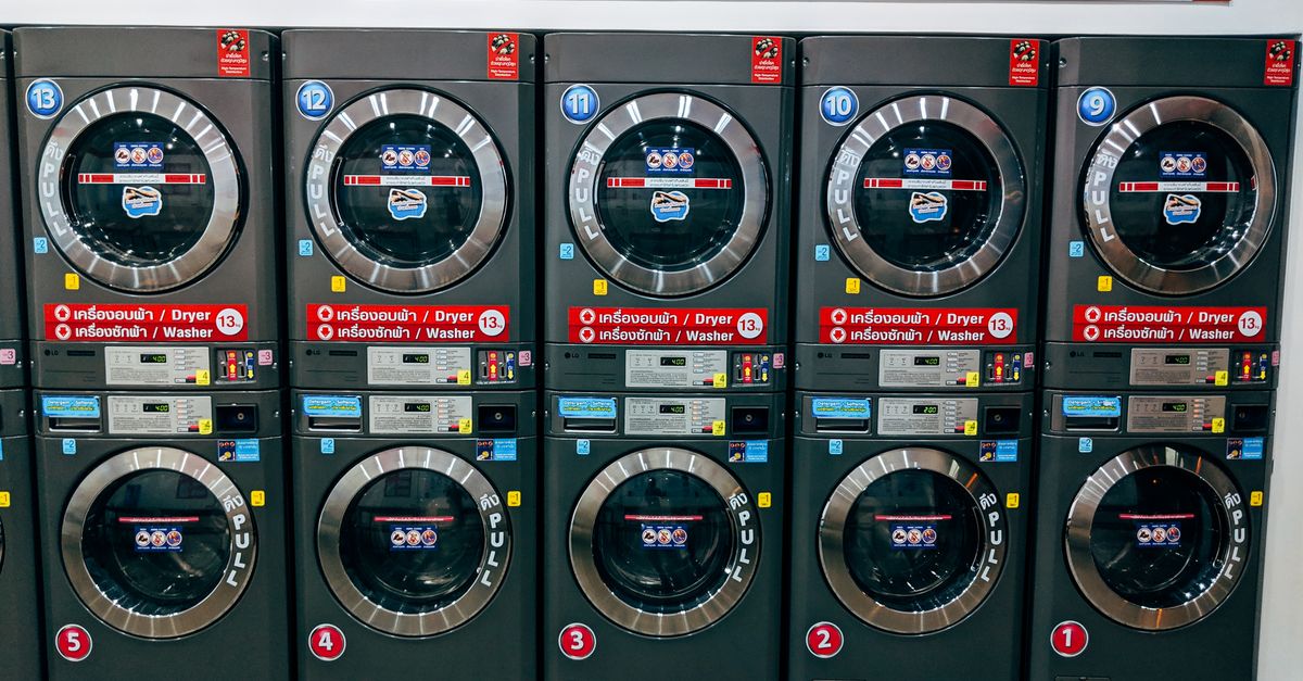 A row of modern washing machines in a public laundromat in Chiang Mai, Thailand.