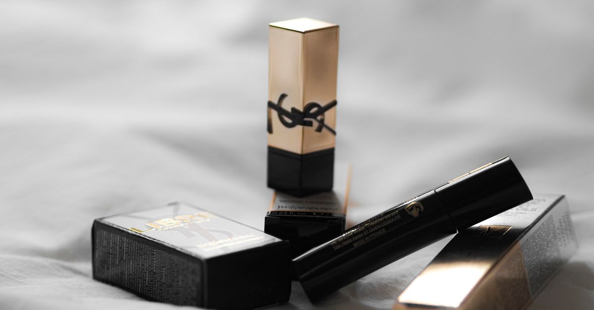 Elegant YSL cosmetics showcased on soft fabric, highlighting luxury beauty products.