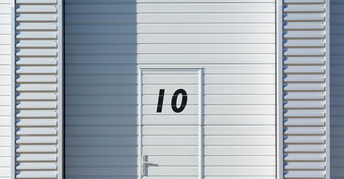 Sleek white metal wall with a numbered door, showcasing minimalistic design and industrial style.