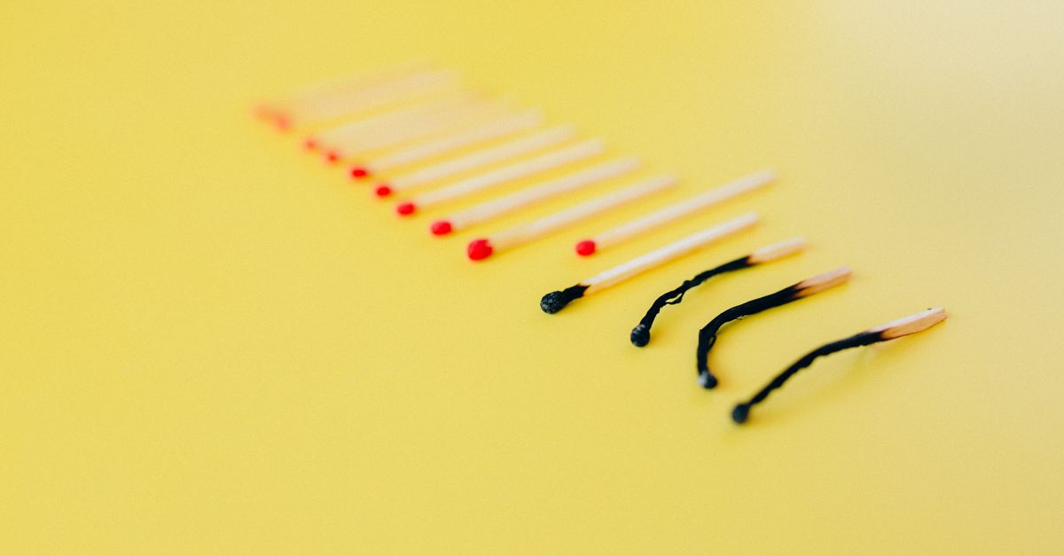 Symbolic representation of burnout using matches on a yellow background, illustrating exhaustion.