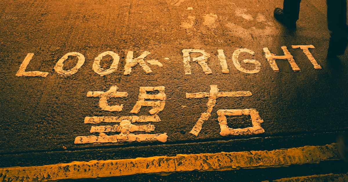 Crosswalk with 'Look Right' and Chinese text, evening street.