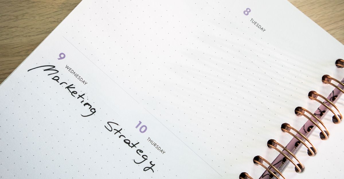 Detailed spiral-bound planner showing marketing strategy notes. Perfect for time management themes.