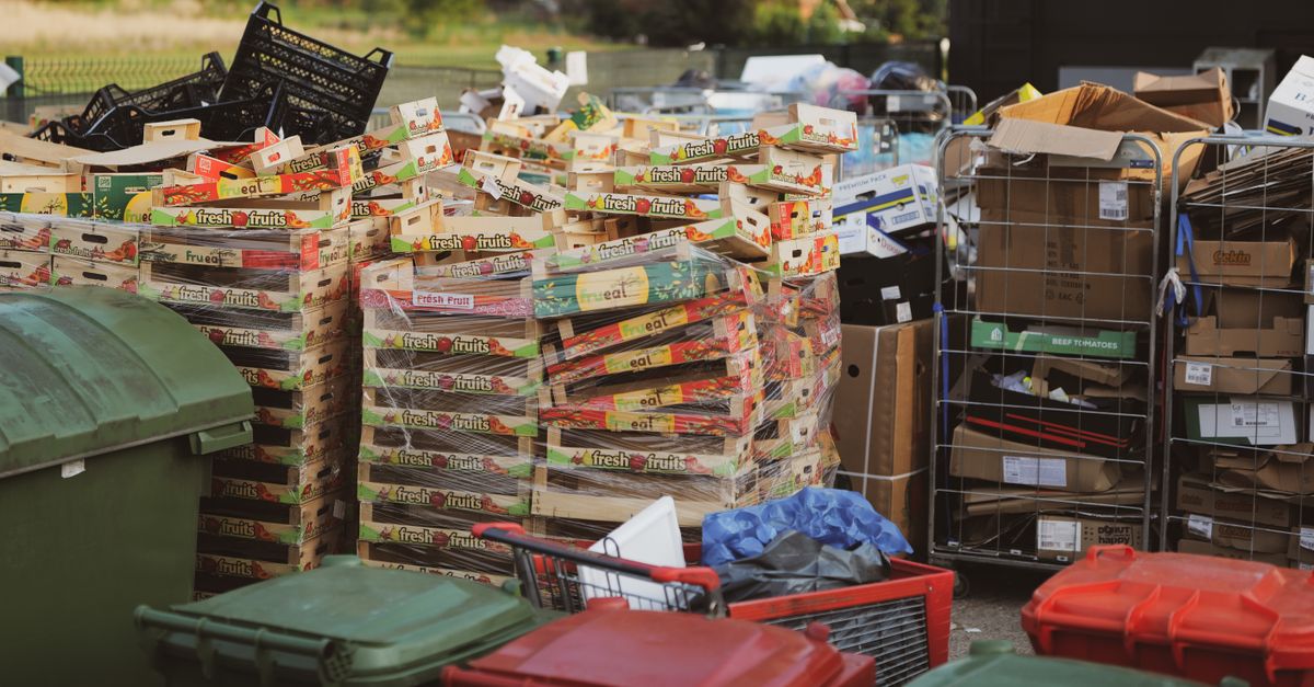 Stacks of carton boxes and bins in an outdoor storage area, exemplifying waste management.