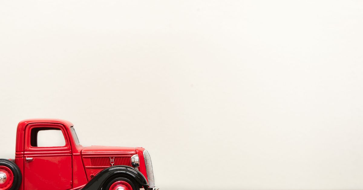 A classic red model truck showcased against a minimal background, perfect for vintage themes.